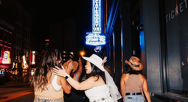 The neon marquee of Luke Combs' Category 10 on Second Avenue at night